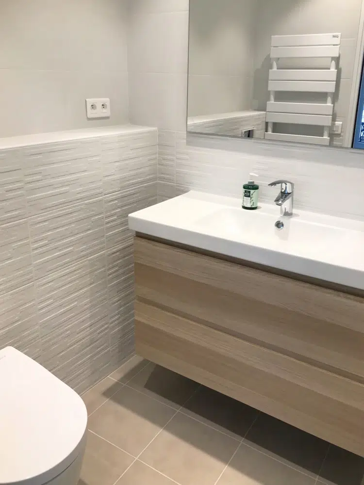 Lavabo blanc et bois dans un appartement pied à terre parisien rénové par Interface Design