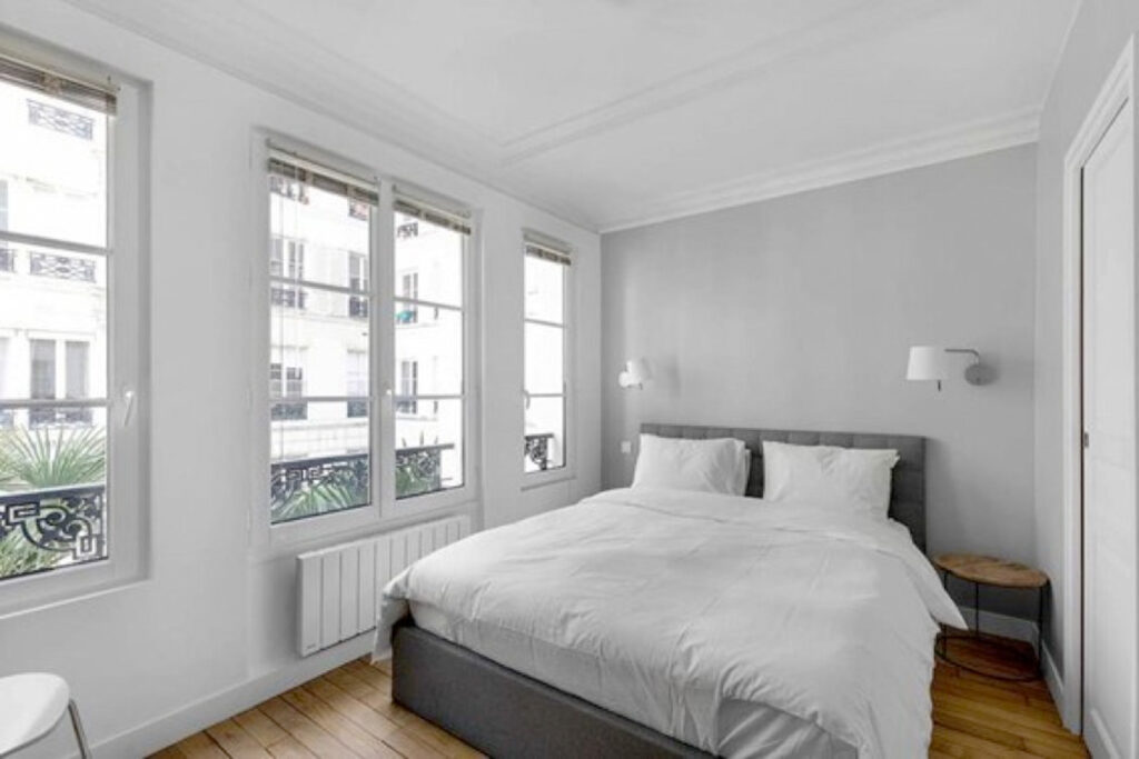 Bright bedroom in a Parisian pied-à-terre apartment renovated by Interface Design