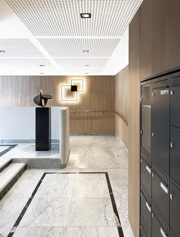 Hall d'entrée moderne noir et bois designé par Interface design pour un promoteur