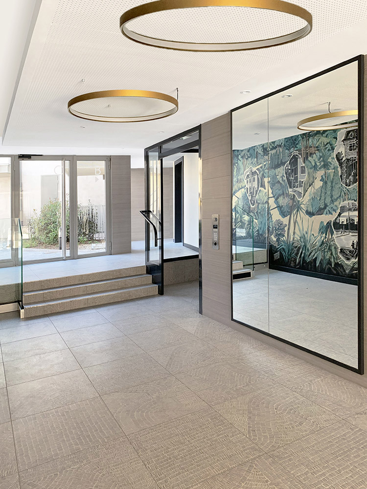 Hall d'entrée blanc et or, avec un grand miroir, designé par Interface design pour un promoteur