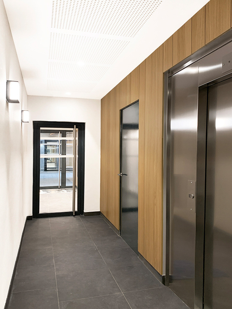 Hall d'entrée anthracite bois moderne et designé par Interface design pour un promoteur